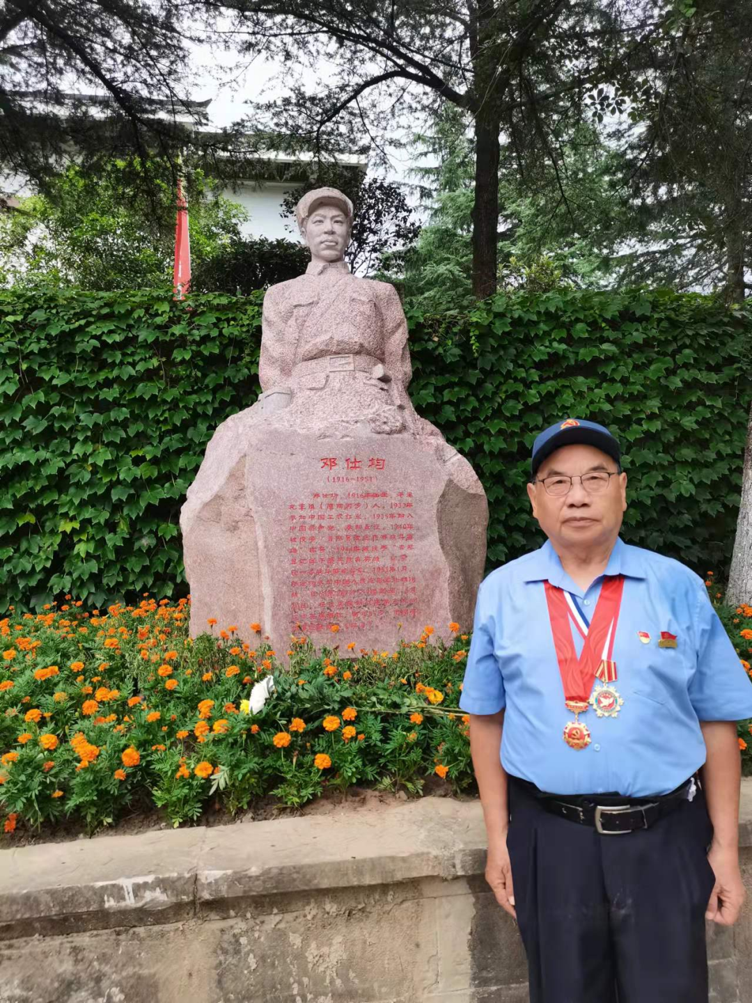 邓其平在四川苍溪县红军渡红军英名堂前,在父亲邓仕均雕像前的照片
